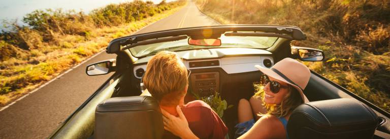 Cabrio met stel rijdt over de weg