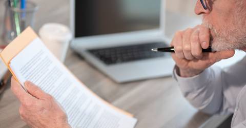 Miljoenennota 2027 ondernemer is document aan het lezen achter zijn bureau